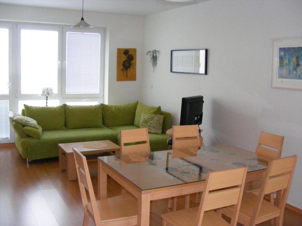 a living room with a green couch and a table at Holiday Home Lipno Frymburk in Frymburk