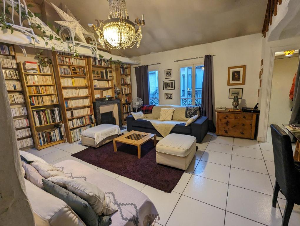 - un salon avec mobilier et étagères dans l'établissement Loft authentique et bohème - Montorgueil, à Paris
