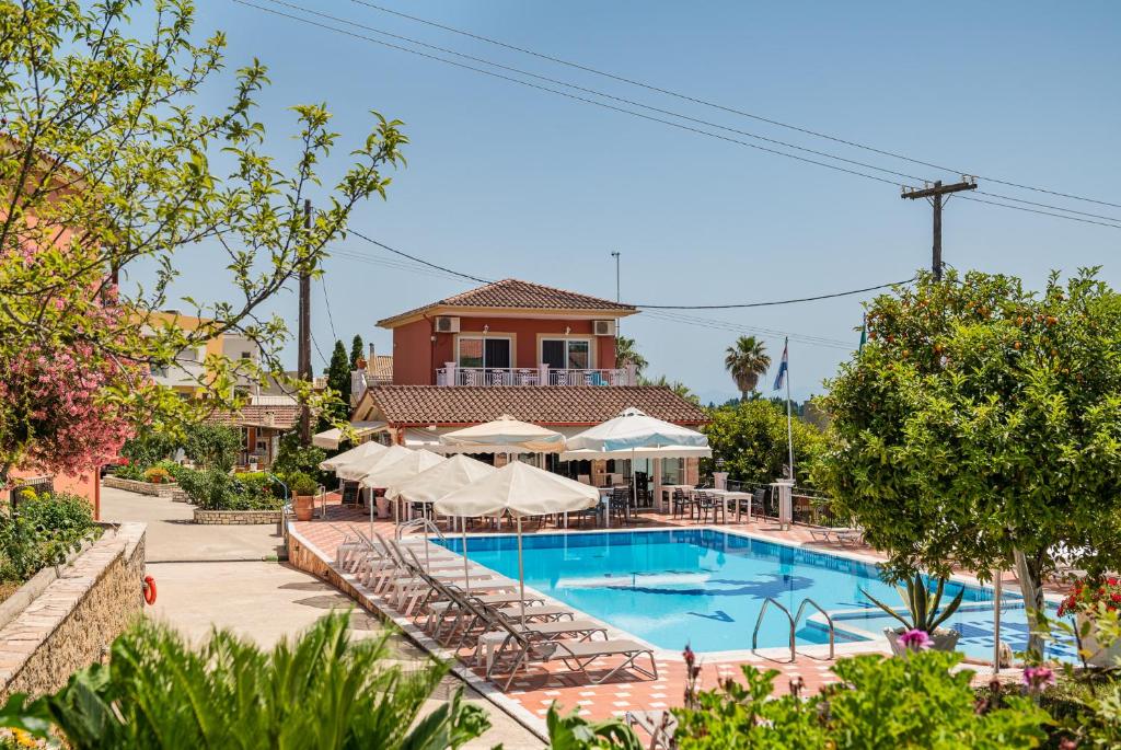 una piscina en un complejo con sillas y sombrillas en Marietta's Resort by Konnect, Gouvia Corfu en Gouvia