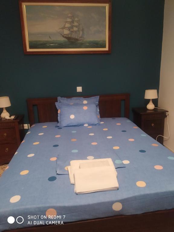 Un dormitorio con una cama azul con dos toallas encima. en DIAS APPARTMENT, en Artemida
