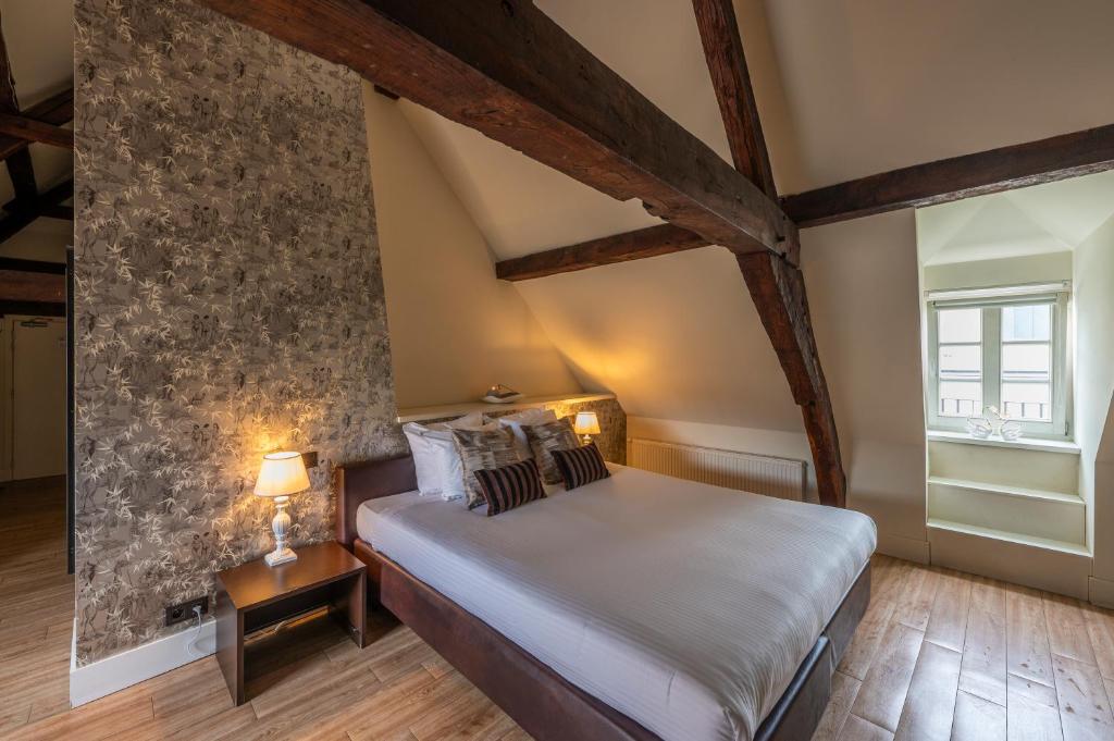 een slaapkamer met een bed en een stenen muur bij Hotel Onderbergen in Gent