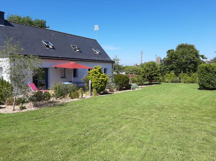 une maison avec une grande cour avec une pelouse dans l'établissement La maison bord de mer, à Trévou-Tréguignec