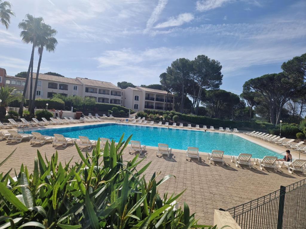 une piscine avec des chaises longues et un complexe hôtelier dans l'établissement domaine de valescure, à Saint-Raphaël