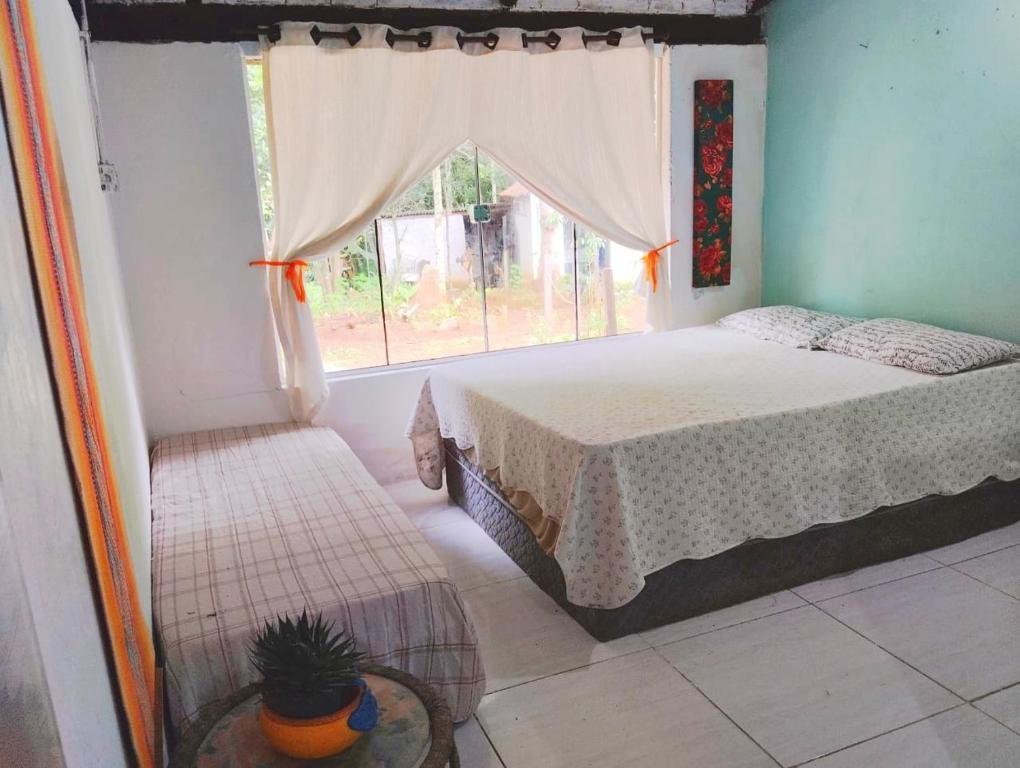 a bedroom with a bed and a window at Chalé Rio Piscina Cozinha Área de Lazer Pertinho da CidadeMaravilha in Pirenópolis