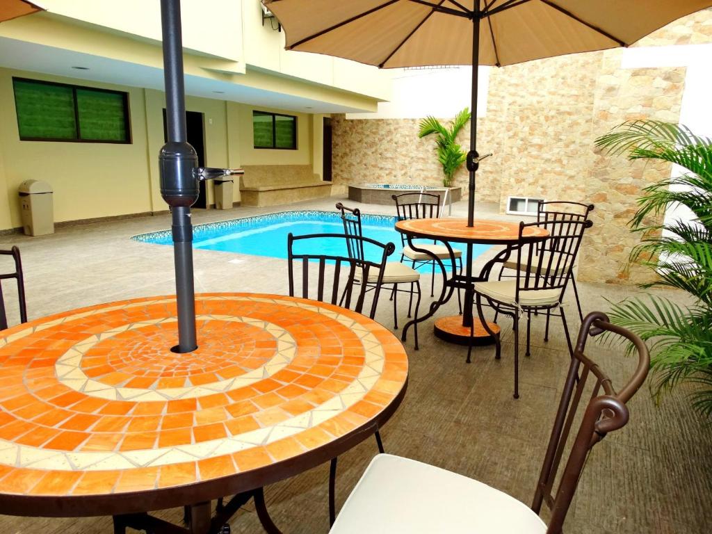 un patio con mesas y sillas y una piscina en Hotel Marvento Suites en Salinas