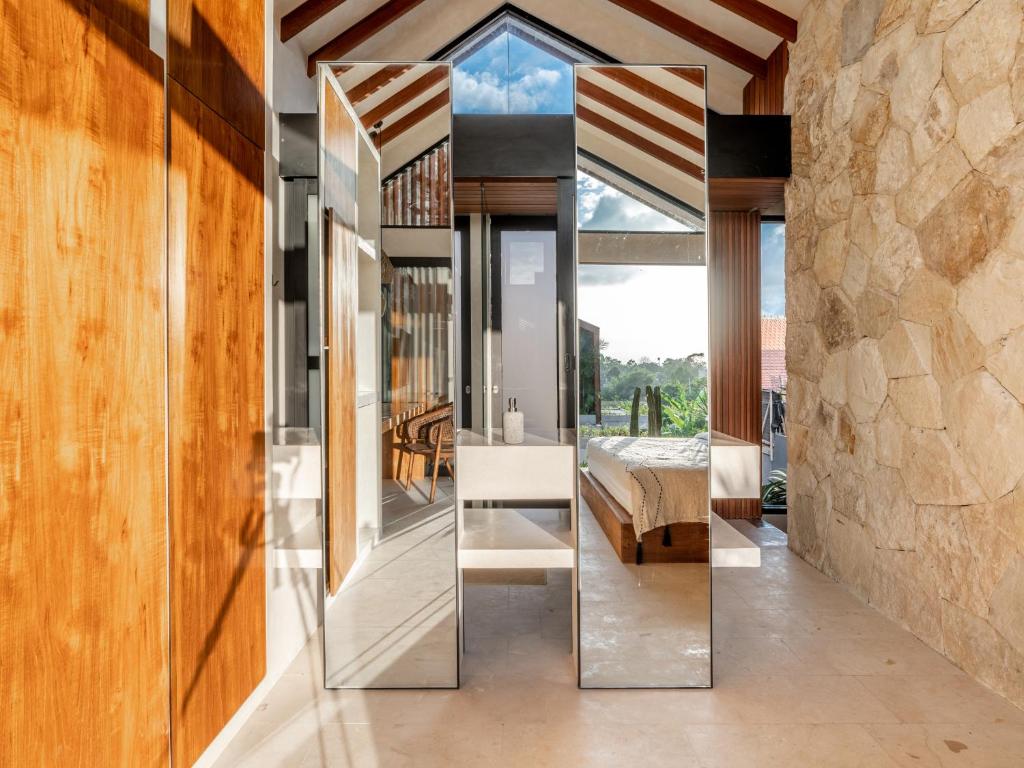 1 dormitorio con espejo en una casa en Blacksand Villas Echo Beach Canggu A4, en Canggu