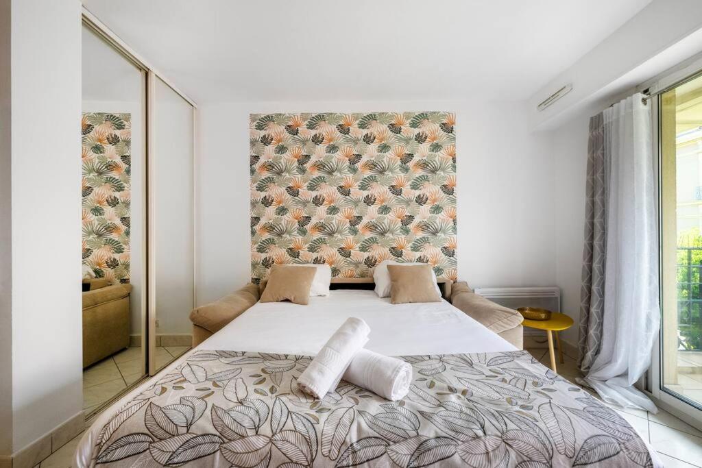 une chambre avec un grand lit avec deux oreillers dessus dans l'établissement Victoria Beach - Charmant studio hyper centre ville de Menton - Mer au pied de l'immeuble, à Menton