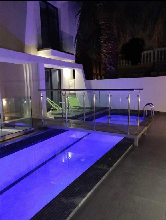 a large swimming pool with purple lights in a building at AquaLux Apartment in Kallithea Halkidikis