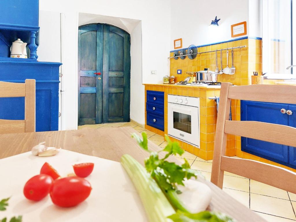 a kitchen with blue cabinets and tomatoes on a table at Forio Family Home in Ischia