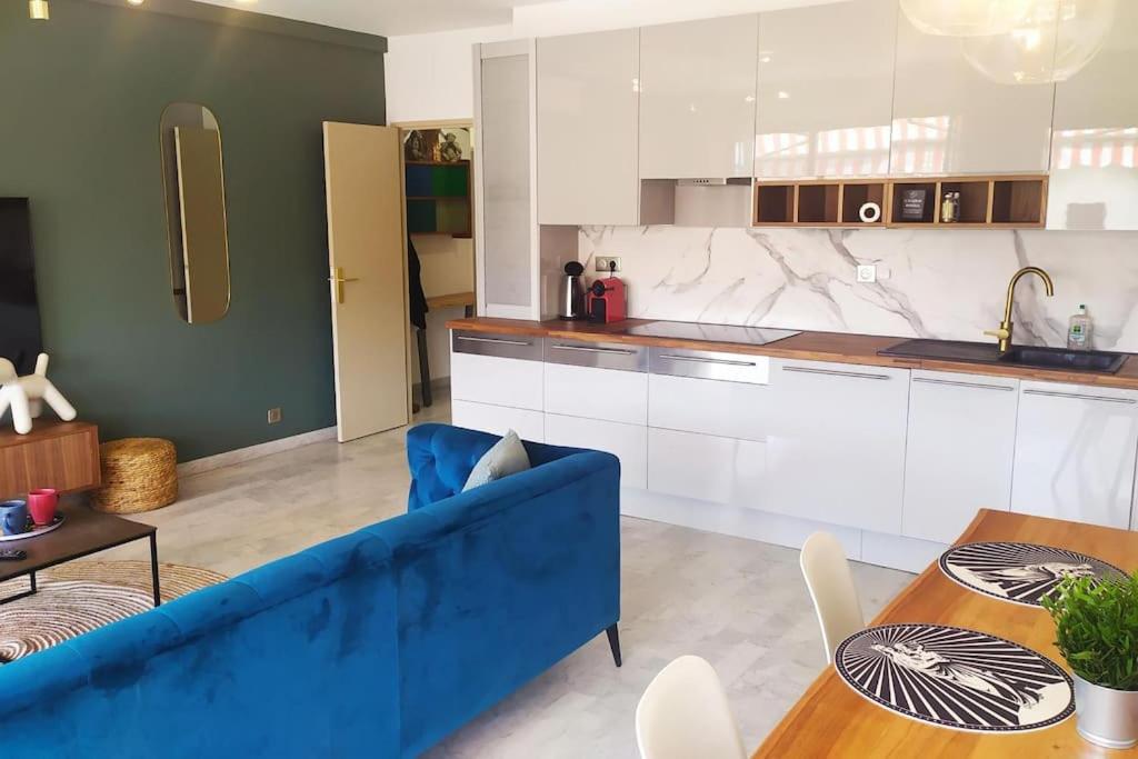 un salon avec un canapé bleu et une cuisine dans l'établissement Marseille Mazargues St Anne, à Marseille