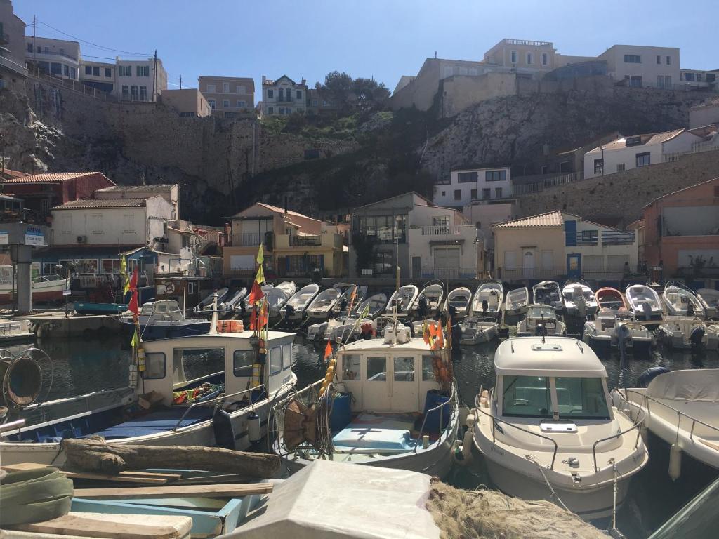 Ein Haufen Boote in einem Hafen mit Gebäuden. in der Unterkunft vue de rêve au vallon des auffes, 13007 marseille in Marseille