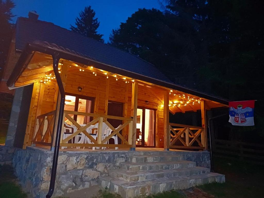 eine Blockhütte mit Weihnachtslichtern in der Unterkunft Brvnara Smrčica in Bajina Bašta