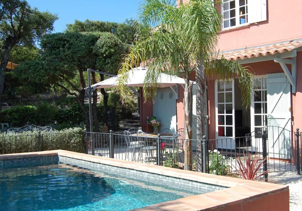 - une piscine en face d'une maison rose dans l'établissement Villa Provençale 4 étoiles - Piscine & Jardin Zen, à Sainte-Maxime