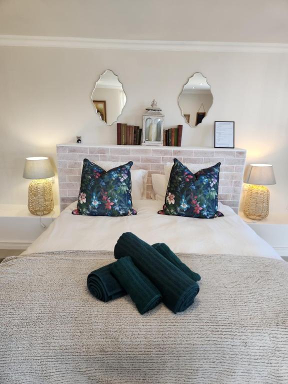 a bedroom with a bed with two pillows at Haus Merwe Self Catering in Cape Town