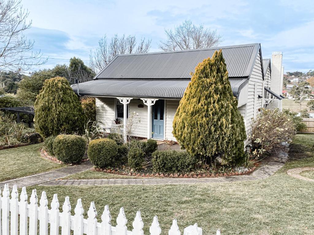 a white house with a fence in front of it at MARIGOLD COTTAGE Charming 1870s central Daylesford cottage in Daylesford