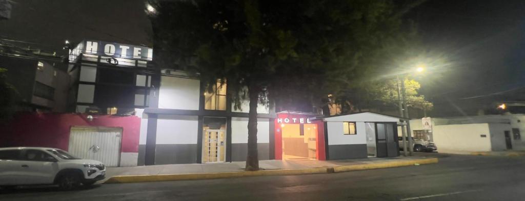 a white car parked in front of a building at night at Hotel Aquario in Mexico City