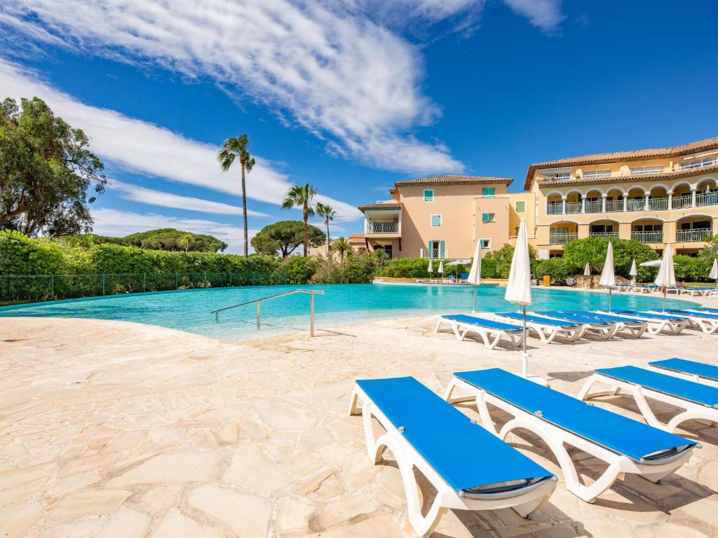 une piscine avec des chaises longues et un complexe hôtelier dans l'établissement Apartment Les Rivages des Issambres-7 by Interhome, aux Issambres