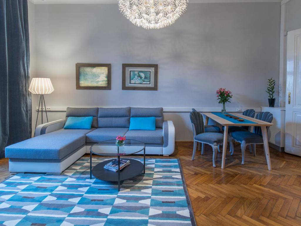 - un salon avec un canapé bleu et une table dans l'établissement LikeHome Apartment, à Zagreb