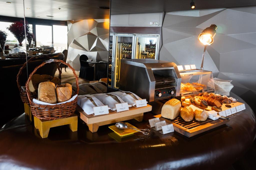 A bakery station with sliced bread, rolls and pastries beside a toaster and warming display.