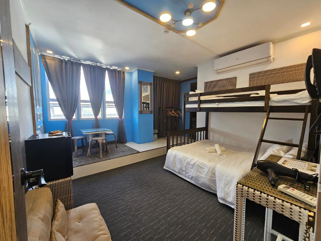 una camera con due letti a castello e una scrivania di Attic Capsule Hotel a Marigondon