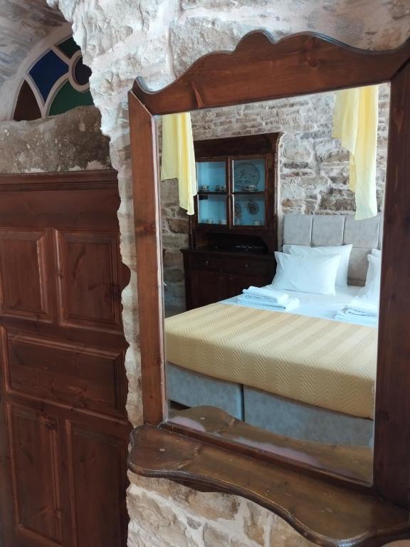 a mirror in a room with a bed and a bed sqor at Vouno Village in Vounós