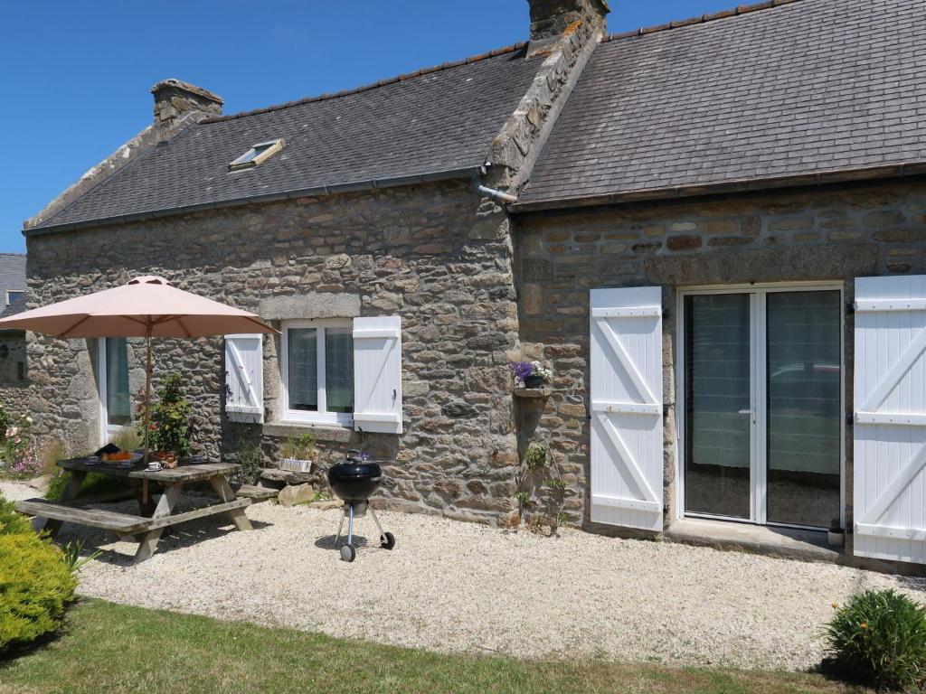 une maison en pierre avec une table de pique-nique et un parasol dans l'établissement Holiday Home Ty Coz ar Mor by Interhome, à Portsall