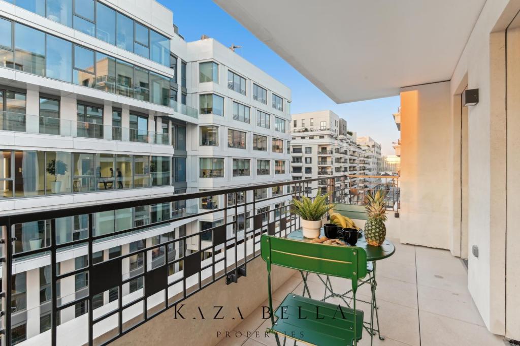 Cet appartement dispose d'un balcon avec une table et des plantes. dans l'établissement KAZA BELLA - Saint Ouen Beautiful apartment, à Saint-Ouen