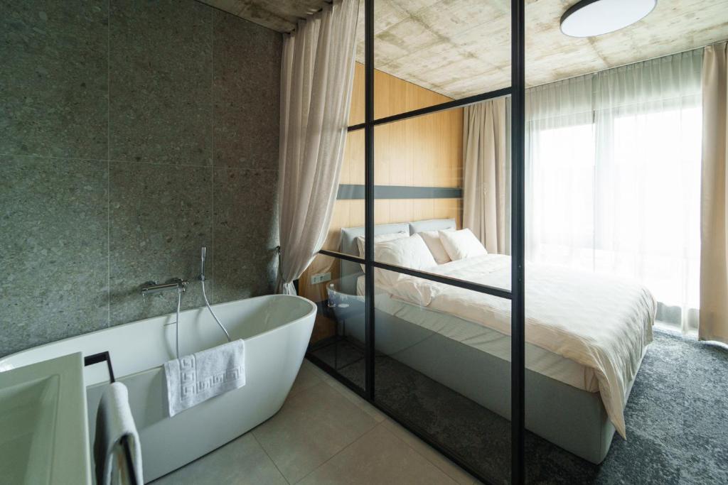 a bathroom with a bed and a tub and a bed at Air Hotel in Karmėlava