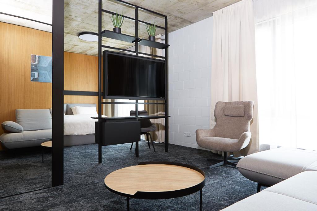 a living room with a bed and a tv at Air Hotel in Karmėlava