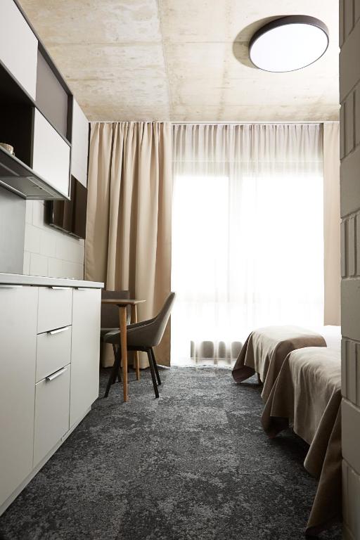 a bedroom with a bed and a desk and a window at Air Hotel in Karmėlava