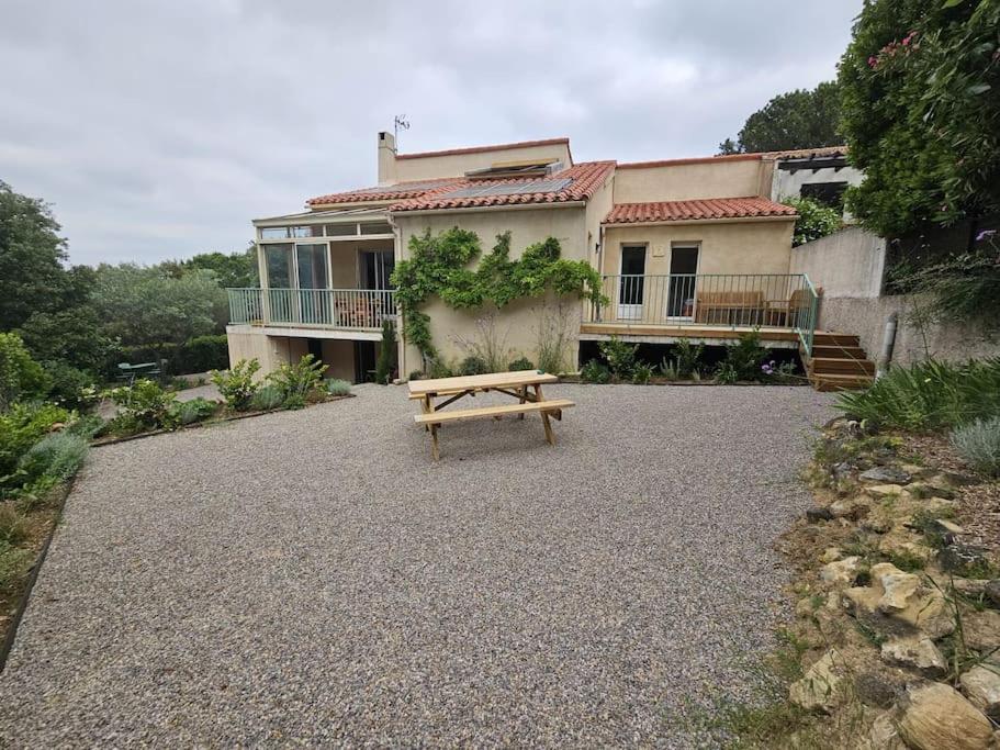 un banc en bois assis devant une maison dans l'établissement Havre de paix en famille !, à Coursan