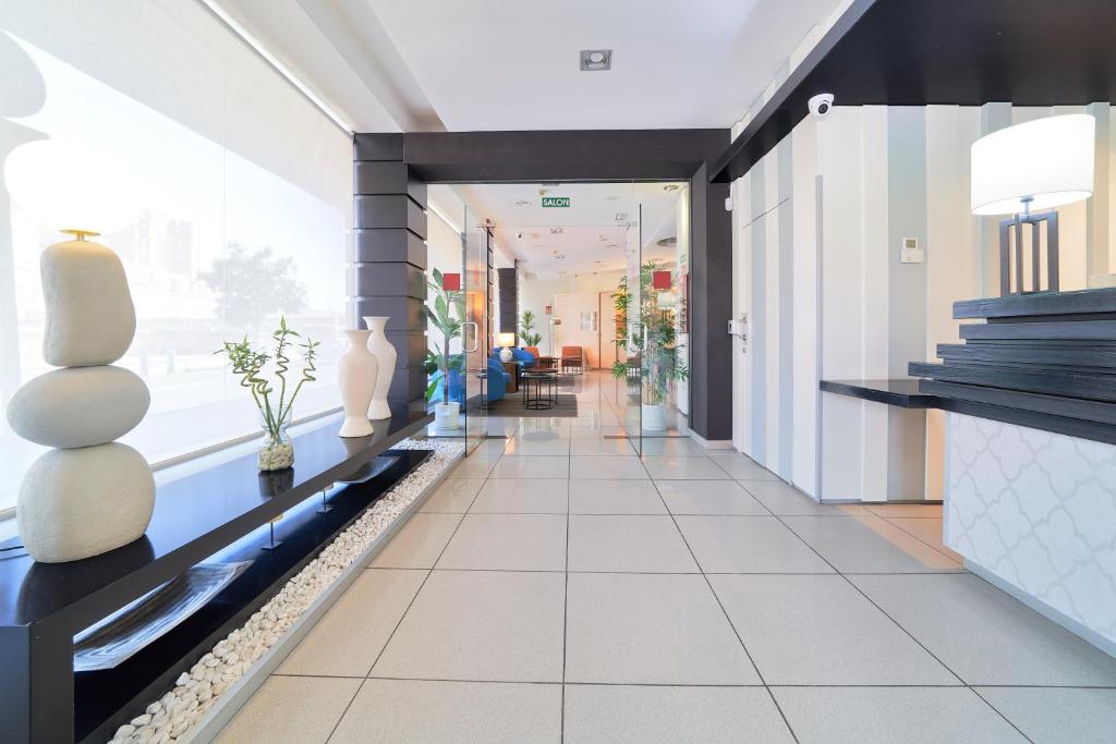 a hallway of a building with vases on a counter at Hotel Guadalmedina in Málaga
