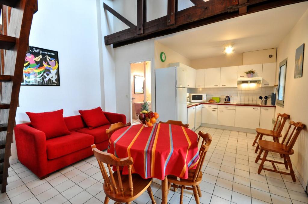 uma sala de estar com um sofá vermelho e uma mesa em Résidence d'Aquitaine em Vieux-Boucau-les-Bains