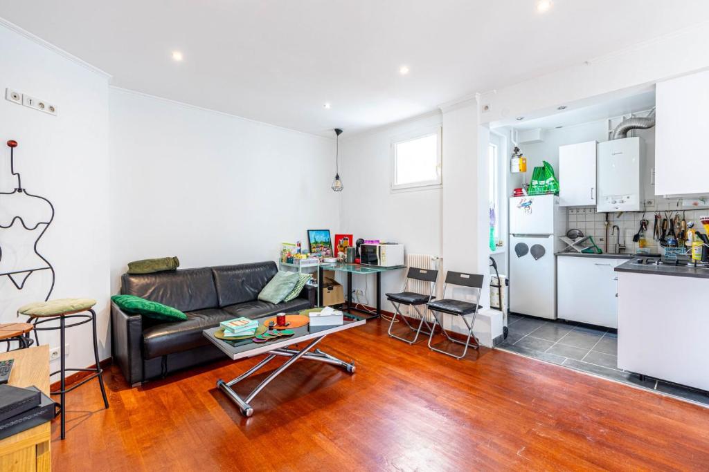 un salon avec un canapé et une cuisine dans l'établissement GuestReady - Bright stay next to The Eiffel Tower, à Paris
