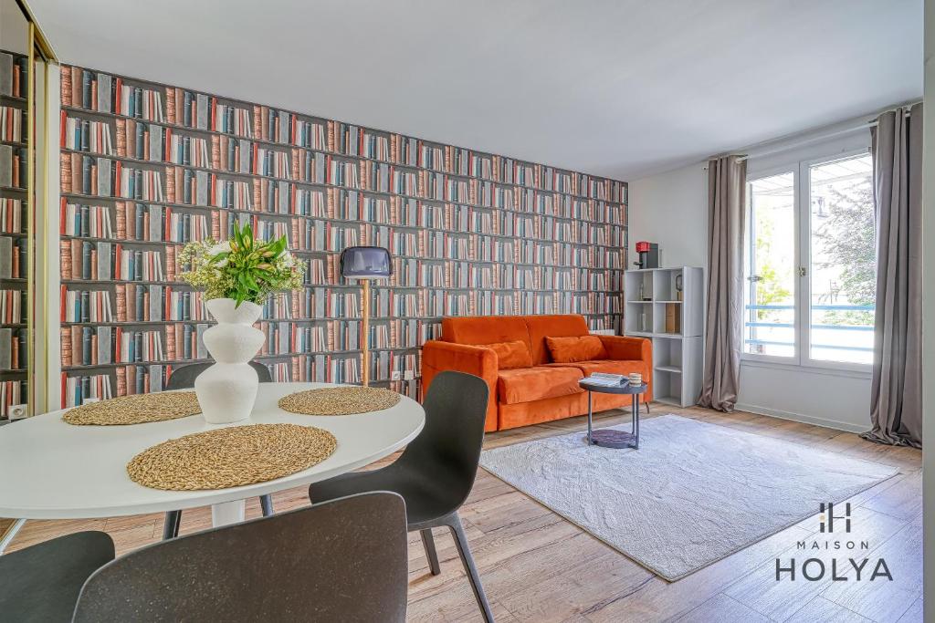 un salon avec un canapé orange et une table dans l'établissement Le Curieux - À deux pas de Paris - 314B, à Rueil-Malmaison