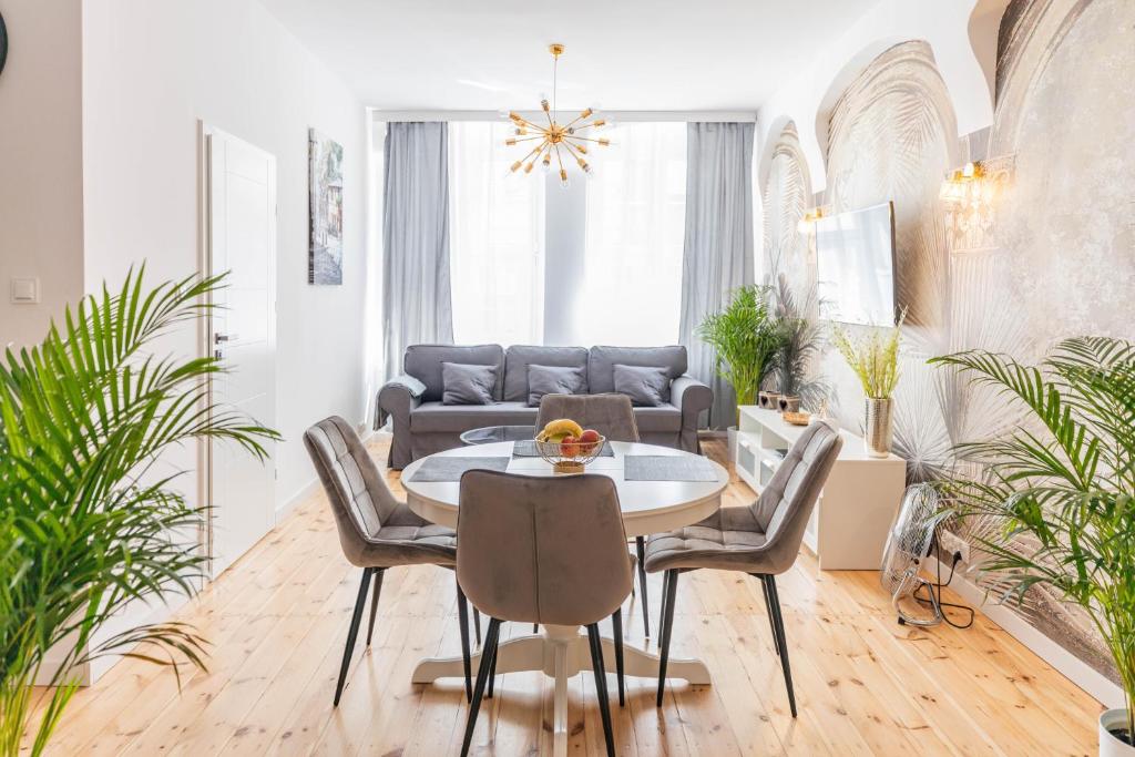 a living room with a table and chairs and a couch at Apartament Podkoziołek Stary Rynek in Poznań