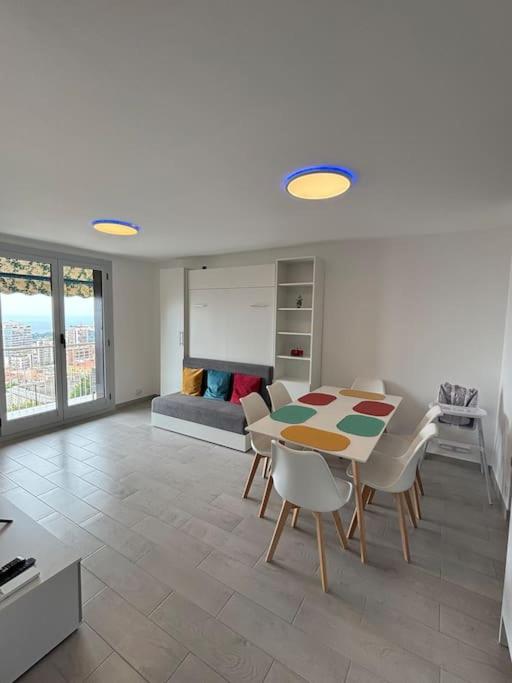 Hotel Appartement tout confort & Parking, a living room with a table and chairs and a couch at Appartement tout confort & Parking in Beausoleil