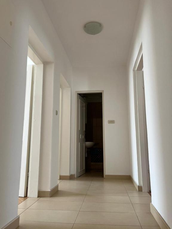 an empty hallway with white walls and floors and doors at Apartmani Ana in Sukošan