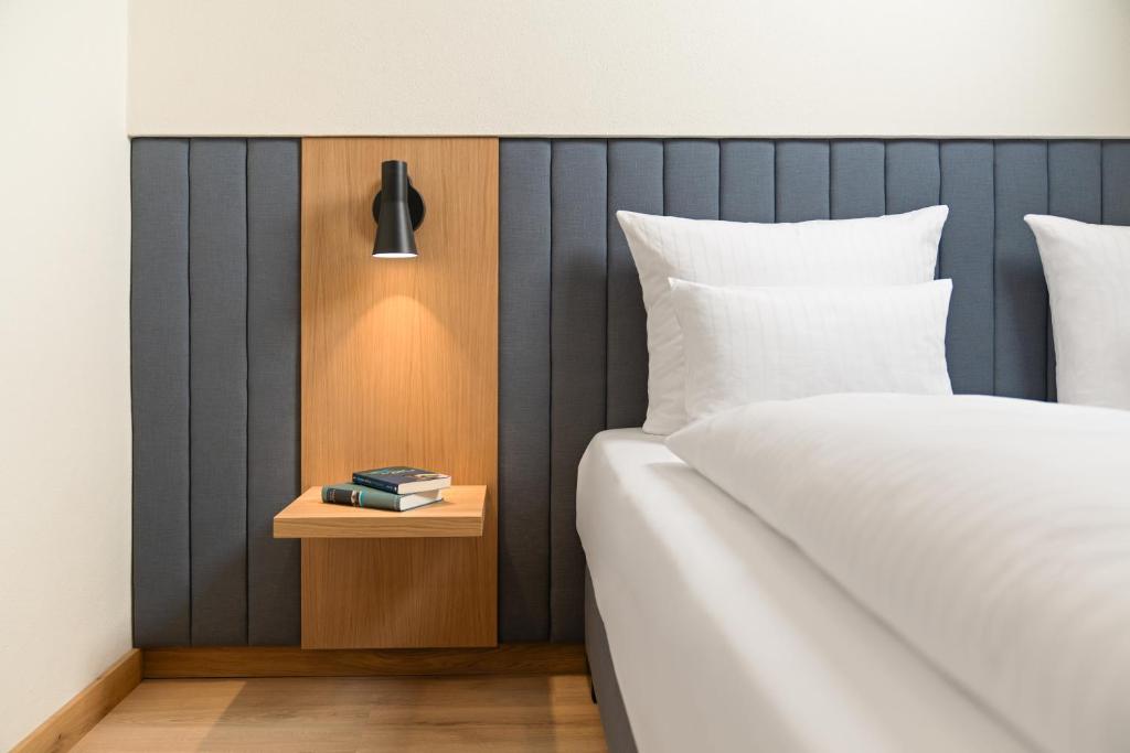 a bedroom with a bed and a nightstand with a side table at Hotel Dreiflüssehof Haupthaus in Passau