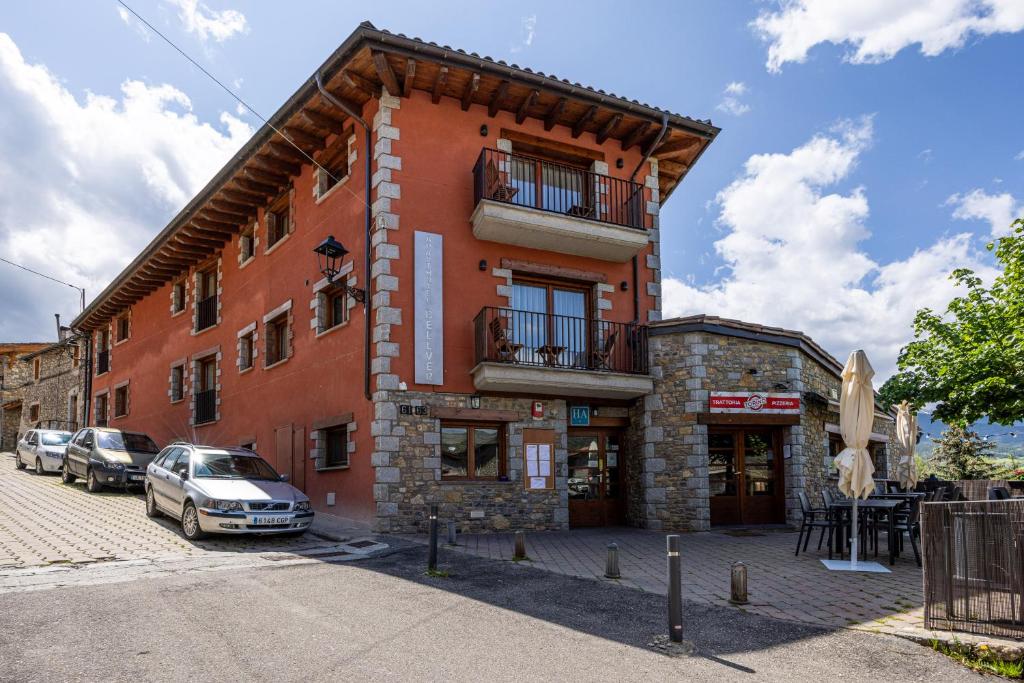 a red building with cars parked in front of it at Aparthotel Bellver in Bellver de Cerdanya