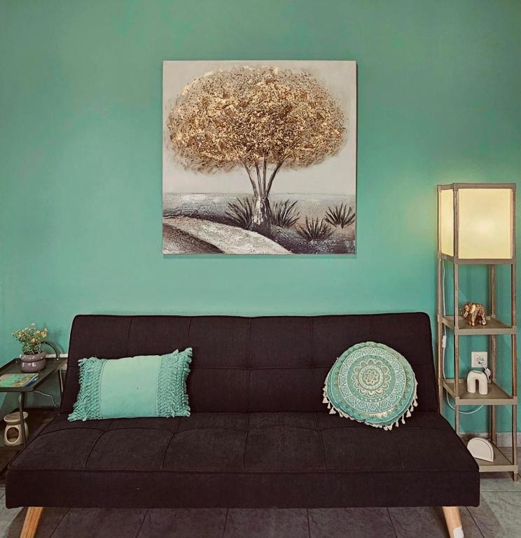 a black couch in a living room with a tree at VMA Residence in Artemida