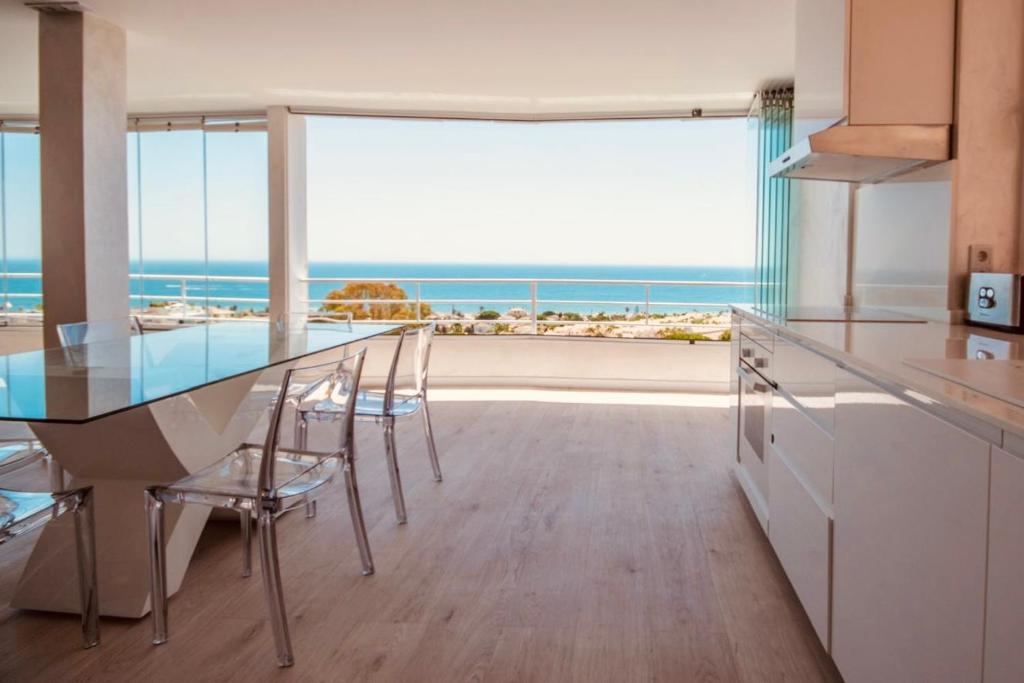 cocina con mesa de comedor y vistas al océano en Penthouse Seaview - destination apartments Marbella, en Marbella