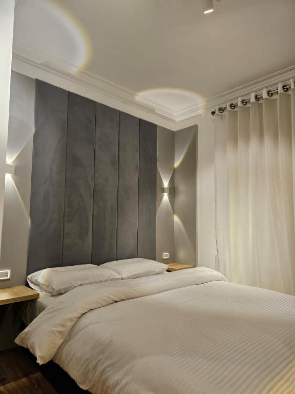 a bedroom with a large bed with a gray headboard at Cozy Homes in Cairo