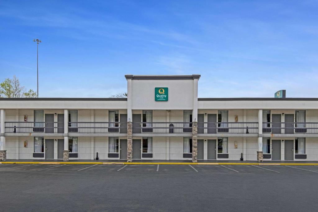 a large white building with a parking lot at Quality Inn in Dalton