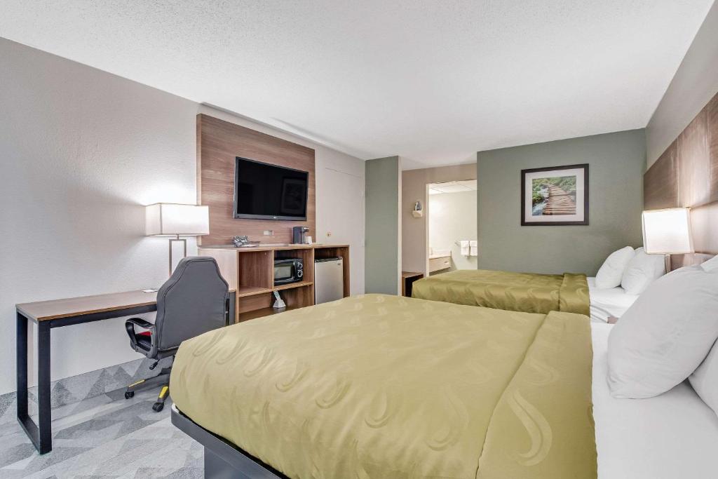a hotel room with a bed and a desk at Quality Inn in Dalton