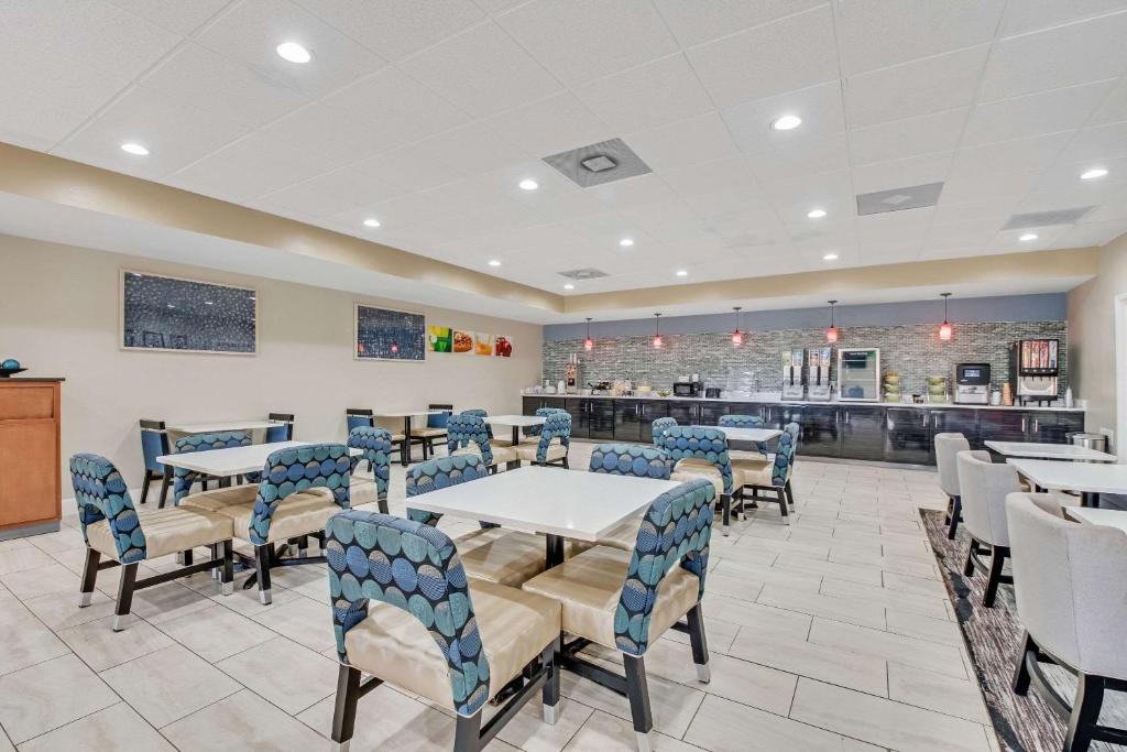 a restaurant with tables and chairs and a counter at Quality Inn in Dalton