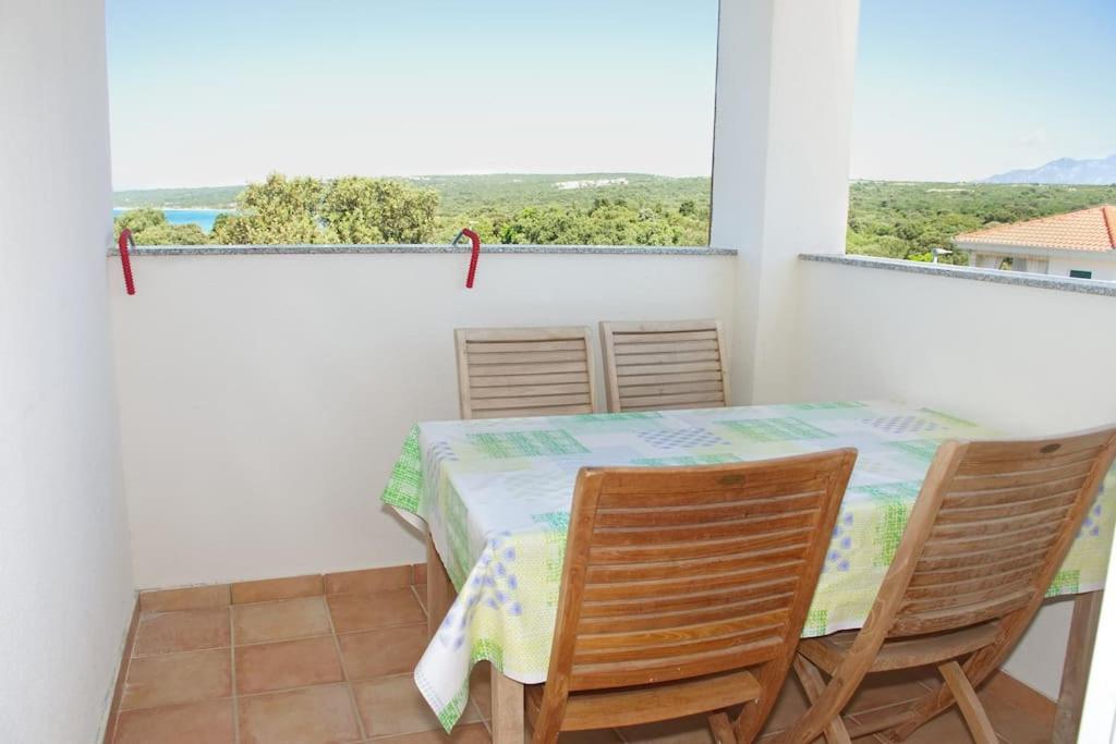 a dining room with a table and chairs and a window at Beachside Babe in Novalja