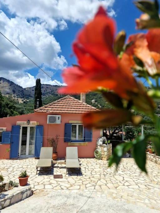 a house with two chairs and a flower in front of it at Mountain Breeze Cottage in Makriótika