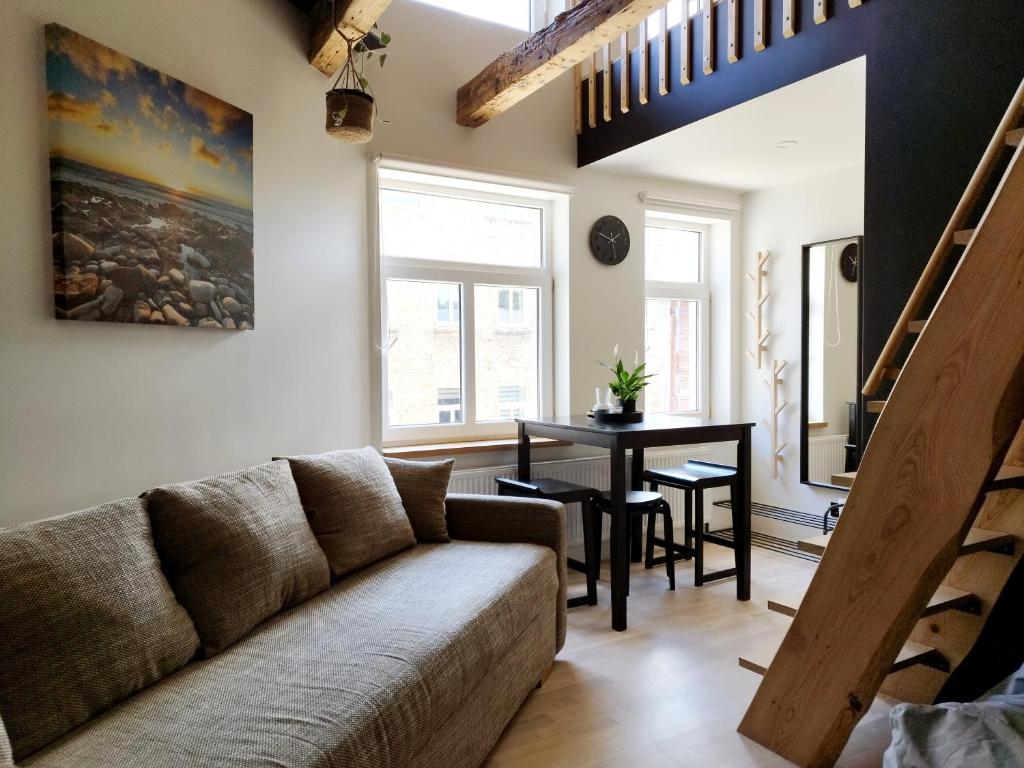 a living room with a couch and a table at Courtyard Condo Sunset in Liepāja