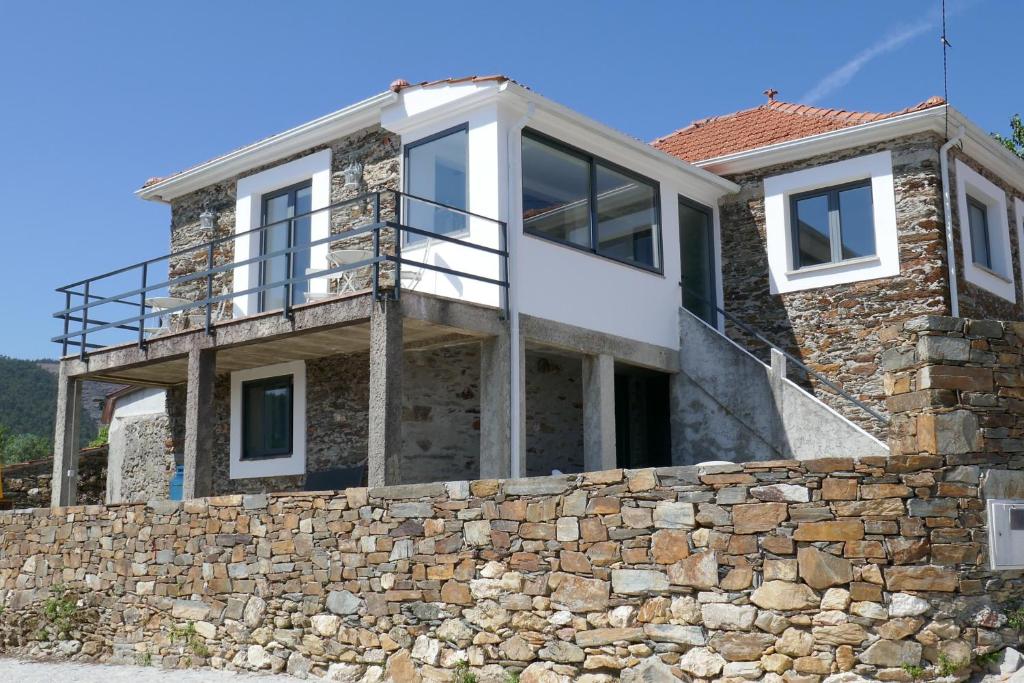 une maison avec un mur de pierre dans l'établissement Casa Adega, à Vale de Cameiro